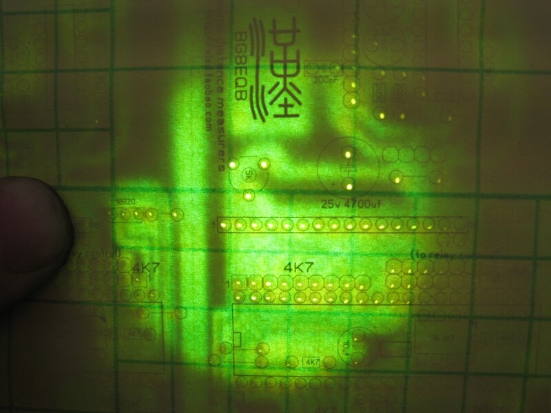 把顶层剪好的纸对好PCB板。用强光LED电筒对照，对好丝网。